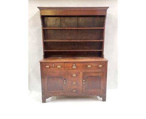A George III country oak dresser, circa 1800, plate rack, moulded top, triple frieze drawers, with later oval brass handles, 