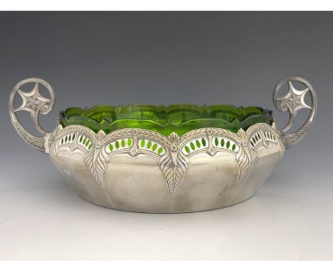 WMF, a Jugendstil silver pated twin handled bowl with green glass liner, embossed laurel arcading, reticulated, with C scroll