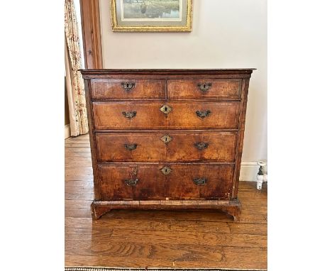 A George I walnut crossbanded chest of drawers, circa 1720 and later, rectangular oak top above two short and three long grad