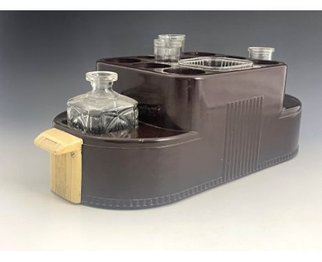 An Art Deco bakelite bar set/cocktail caddy, with glass decanters, ice bucket and glasses, 60cm long