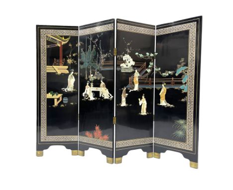 A Chinese black laquered four fold screen, with applied hardstone and jadeite figures and floral decoration, on bracket style