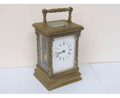 A Victorian brass carriage clock with Wrythen-form corinthian column supports, striking and repeating mechanism, with Roman e