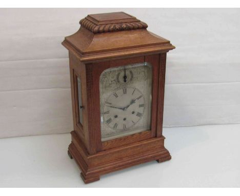 A late 19th/early 20th Century oak bracket clock of architectural form, engraved Roman silvered chapter ring with chime/silen