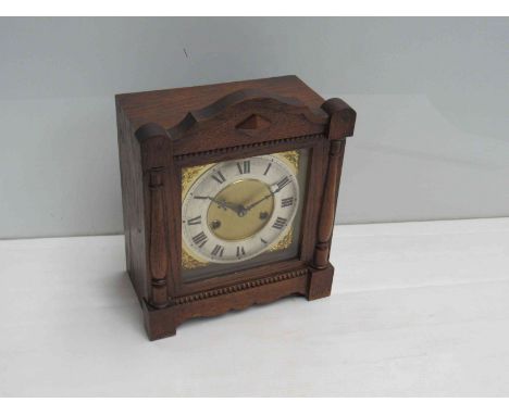 An early 20th Century oak cased mantel clock with silvered Roman dial, 8 day Ansonia striking movement, key and pendulum, 28c