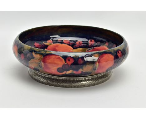 A WILLIAM MOORCROFT POMEGRANATE DESIGN TUDRIC PEWTER BASED FRUIT BOWL FOR LIBERTY &amp; CO, the shallow bowl of circular form