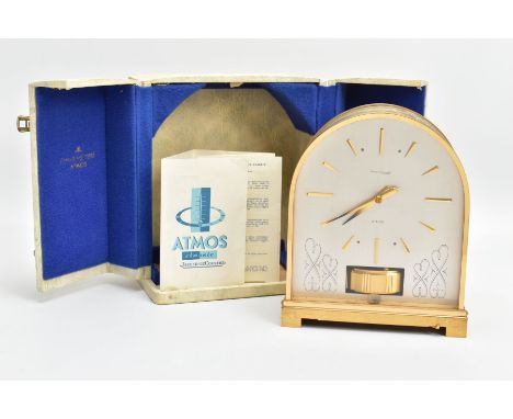 A JAEGER LE COULTRE ATMOS ARCHED BRASS MANTEL CLOCK, the case with a bands of scrolls and raised stripes, the silvered dial w