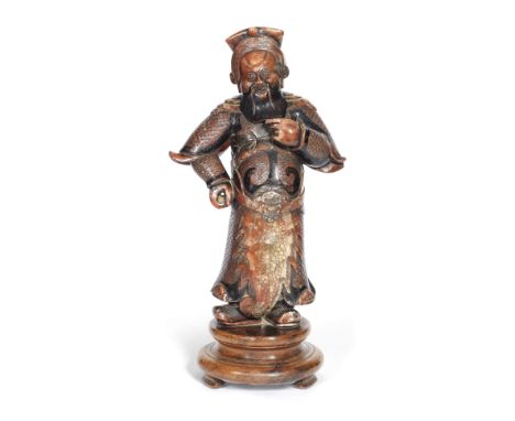 A SOAPSTONE FIGURE OF GUANDI19th centuryThe figure wearing a hat with a confronting dragons and pearl design, scale-armoured 