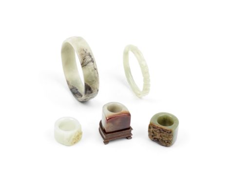 A GROUP OF VARIOUSLY JADE, JADEITE, AND HARDSTONE BANGLES AND THUMB RINGSQing Dynasty and laterComprising: a bowenite dragon 