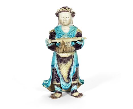A FAHUA-GLAZED BISCUIT FIGURE OF WEITUOKangxiThe figure standing with his hands clasped together, balancing a sword across hi