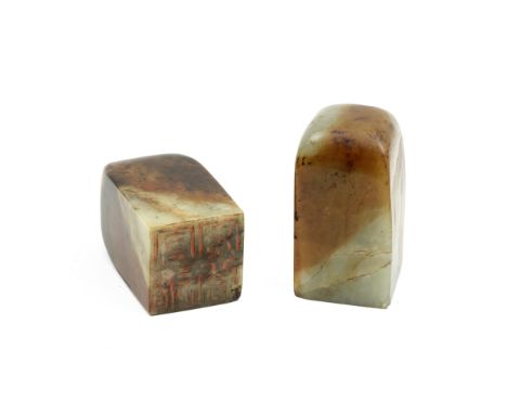 A PAIR OF PALE GREEN AND RUSSET JADE SEALS20th centuryEach square-section body left undecorated and rounded at  the top, with