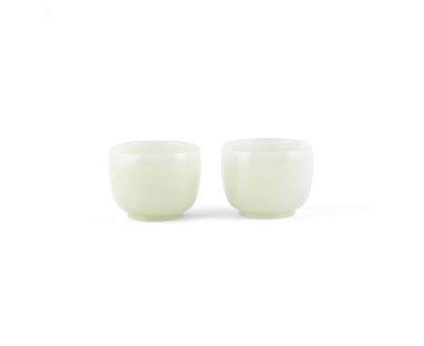 A PAIR OF PALE JADE CUPS18th/19th centuryEach rising from a short foot to a plain rounded body, the stone of very pale greeni