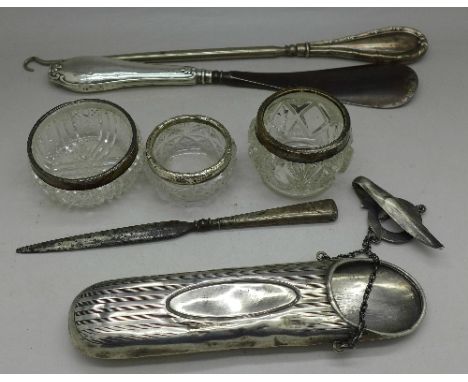 A silver spectacle case, a silver handled letter opener, a button hook, a shoe horn and three silver topped salts