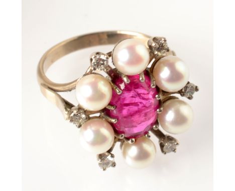 A cabochon oval ruby ring set within a pearl and diamond star.