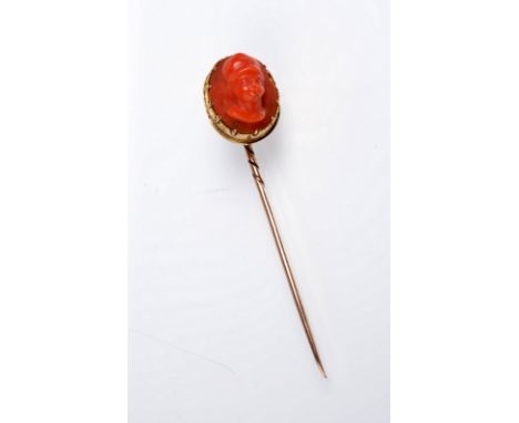 A coral cameo gold stick pin.