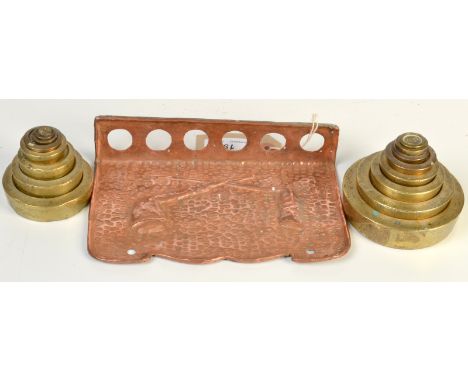 Various nesting brass weights together with a copper pipe rack.