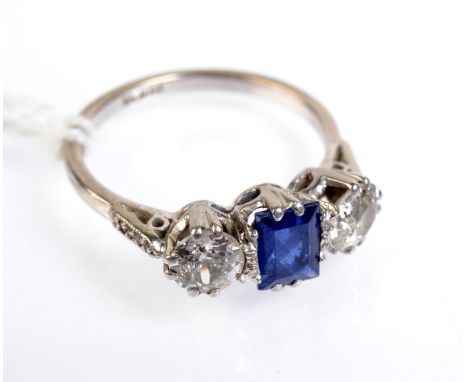 A platinum ring set a rectangular sapphire flanked by diamonds, each diamond of approximately .5ct, within shoulders set with