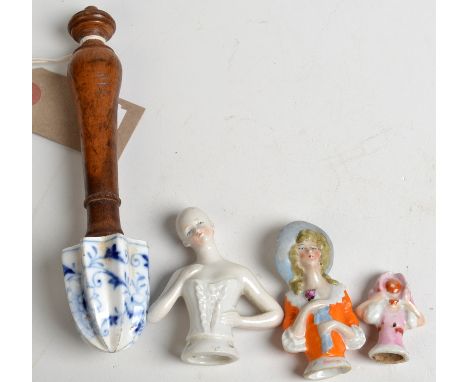 A rare onion pattern lemon squeezer with turned wood handle, possibly Meissen, together with three porcelain half-dolls.