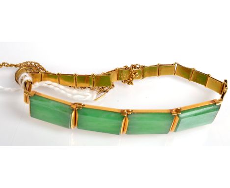 A Chinese gold bracelet with four hinged panels set with jade. 