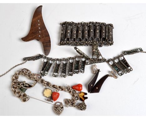 A silver charm bracelet with coral, jade and other charms, a 1960's inlaid hardwood brooch and matching earrings and a filigr