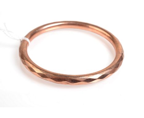 An early 20th century faceted 9ct. gold hollow bangle, Chester hallmarks, 16.8g.