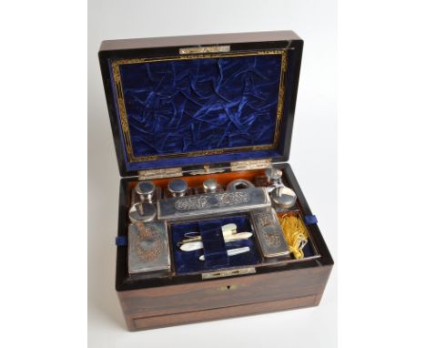 A Victorian rosewood toilet box, the bottles and dishes with plated mounts above a button operated sprung drawer, width 30.5c
