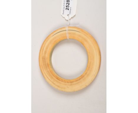 An ivory bangle. Condition Report: Inside diameter is 7.3cm. A few small cracks following the grain.
