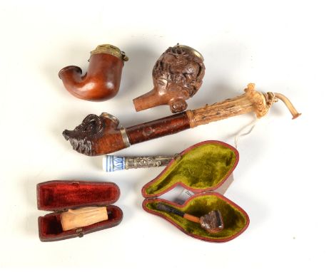 A German tobacco pipe with an antler and briar stem, the small bowl carved with head of an Ibex, length 25cm, together with t