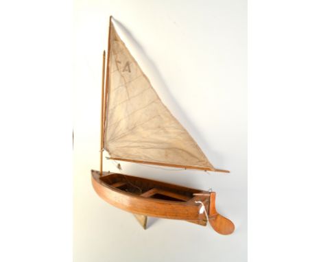 A scale model pond yacht of clinker construction the gaff rigged sail number A.7, the open hull with brass drop keel, length 