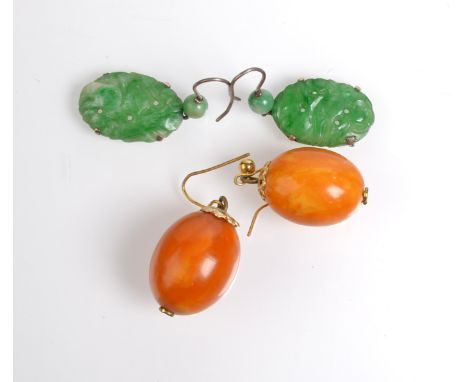A pair of carved jade earrings and a pair of amber earrings. Condition Report: Each earring is about 2cm long, the amber bead