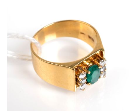 A contemporary gold ring set an oval emerald and six diamonds.