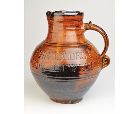 An important early Michael Cardew pottery jug with a rich, toffee brown glaze, incised 'The Best Wine is the Oldest/The Best 