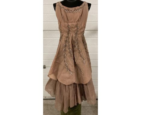 A vintage 1950's Alma Leigh coffee coloured, sleeveless,  A line cocktail dress. With netted underskirt and beaded detail. Zi