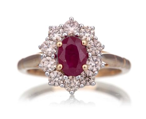 RUBY AND DIAMOND RING set with a ruby of approximately 1.00 carat, within a diamond halo of approximately 0.83 carats, in nin