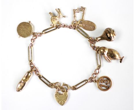 A 9ct yellow gold charm bracelet, the slender bracelet formed of lozenge and chain links hung with seven assorted charms incl