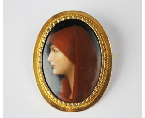 A yellow metal mounted ceramic panel mounted brooch, the panel depicting a lady in a red head scarf, impressed K and coronet 
