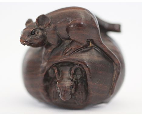 A Japanese carved boxwood netsuke, modelled as two mice and an apple, two character signature to underside, 3.5cm high
