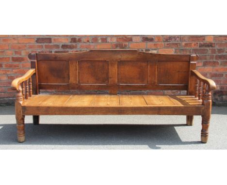 A late George III oak settle, with four panelled back above a solid seat, on turned legs, 87cm H x 190cm W x 68cm D (altered)