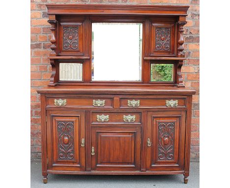 A late Victorian carved walnut sideboard, the raised back with large bevelled plate flanked by two open shelves and two small