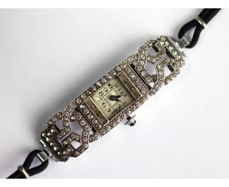 An Art Deco French paste set cocktail watch, in woven ribbon design, set throughout with paste, enclosing the square dial wit