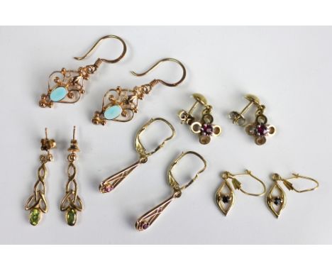 Five pairs of drop earrings, to include; a pair of peridot set Celtic knot drop earrings, two pairs of ruby set earrings and 