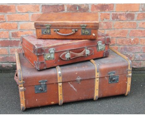 A bentwood bound and canvas lined travelling trunk, 91cm, with two smaller leather suite cases (3)