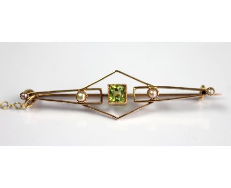 A peridot and seed pearl set brooch, designed as a central square cut peridot flanked by seed pearls to either side, all set 