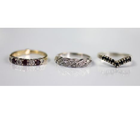 Three rings, to include; a diamond set and white gold 'twist' design ring, indistinctly marked, a ruby and diamond seven ston