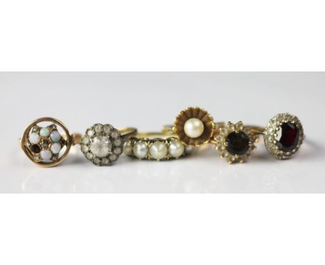 A collection of six assorted rings, to include; an opal and diamond 'star' ring within circular surround (one opal missing) h