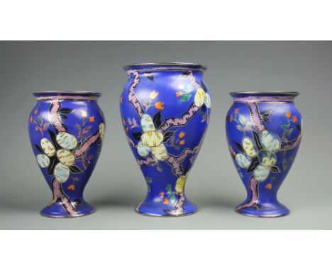 A garniture of three Carlton Ware vases, decorated with fruiting trees against a deep blue ground, tallest 24cm (3)   CONDITI