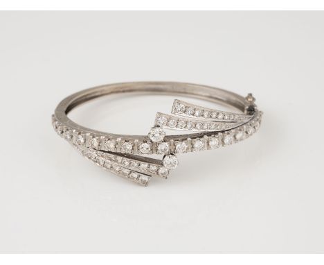ARMREIF Weißgold. Innenmaß ca. 5,7 x 5,0 cm, Ges.-Gew. ca. 32,4 g. Geprüft mindestens 14 K. 57 Diamanten im Brillant- und 8/8