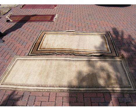 An antique rug with light brown ground - 198cm x 138cm, together with one other - 232cm x 105cm 