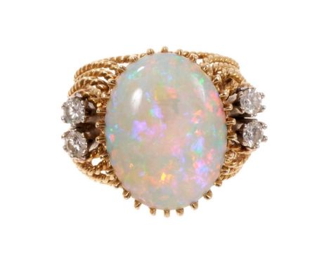 1960s opal and diamond cocktail ring with a large cabochon opal, measuring approximately 18.8mm x 14.1mm, flanked by four bri