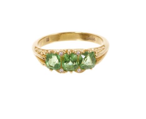 Victorian style peridot and diamond ring with three oval mixed cut peridots in carved gold setting with diamond accents to th