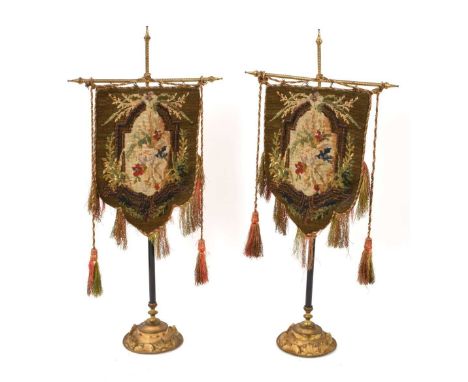 Pair of 19th century tapestry and beadwork table screens, each with needlework and beadwork banner on gilt heightened column,